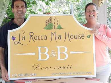 Innkeepers Margaret and Domenico hol the sign to their B&B in Roccacasale, Italy in the region of Abruzzo.